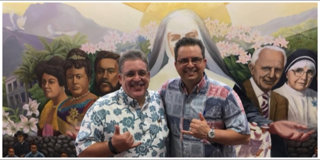 Image of Jerry Correa, head of Saint Francis Healthcare which oversaw the convent, with Saint Louis High School president Glenn Medeiros in front of a colorful mural on the Saint Louis campus depicting Mother Marianne Cope and other historic personalities.